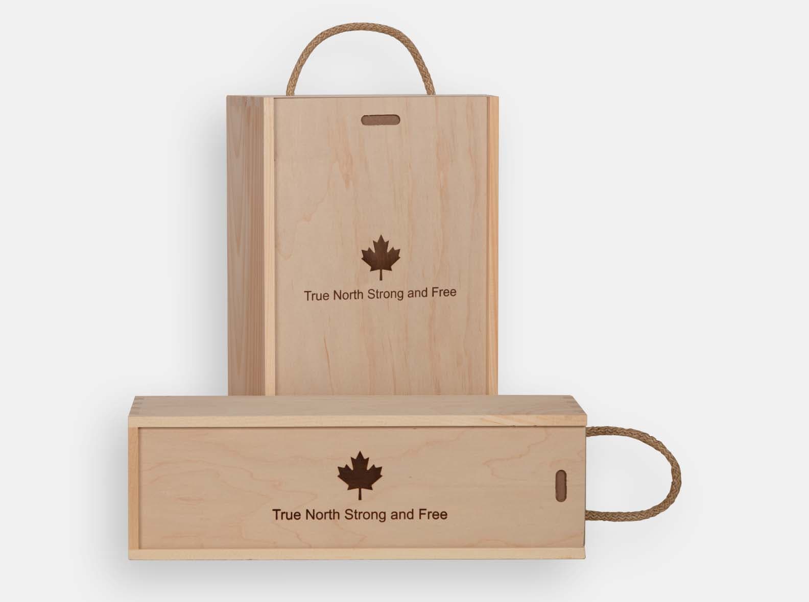 Two custom maple wine boxes engraved with a maple leaf and the words True North Strong and Free."